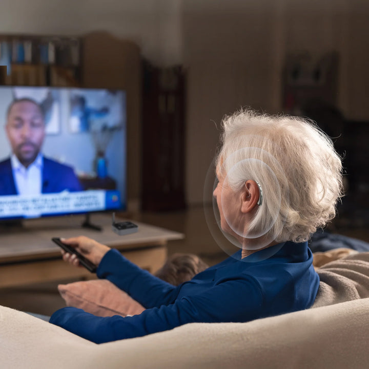 Woman wearing a hearing aid while watching TV