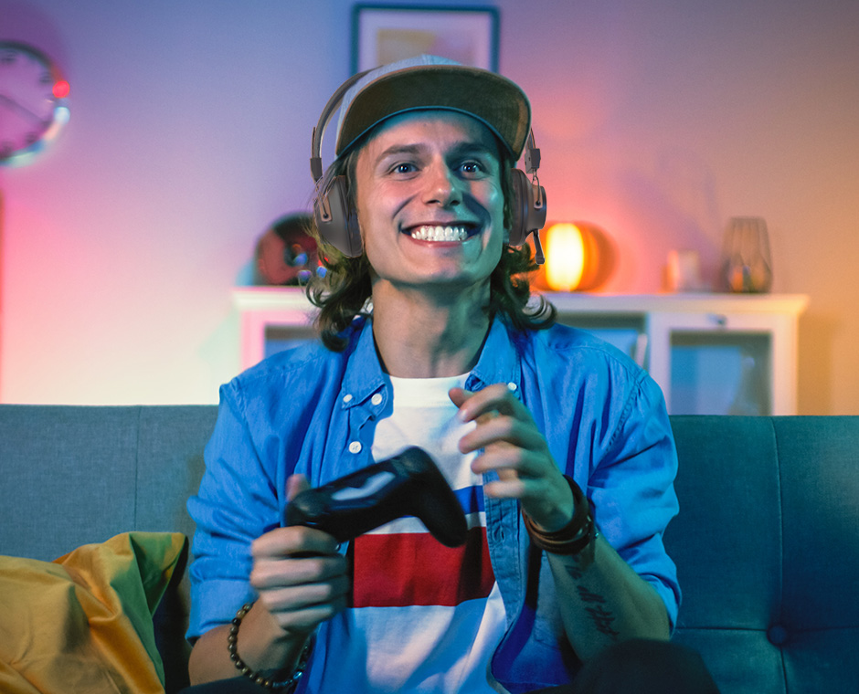 Man wearing the DG59M Bluetooth Headphones with Mic while holding a PS4 Dualshock Controller, playing games on PS4.