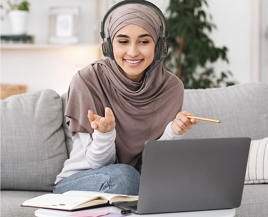 Muslim lady working from home and using the Avantree DG59M Bluetooth headset for online conference call meetings.