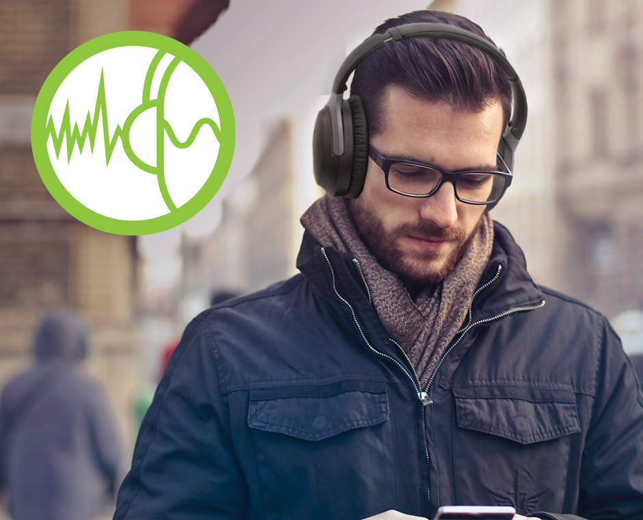 Man wearing the Aria 8090T noise cancelling Bluetooth 5.0 headphones on a noisy street.