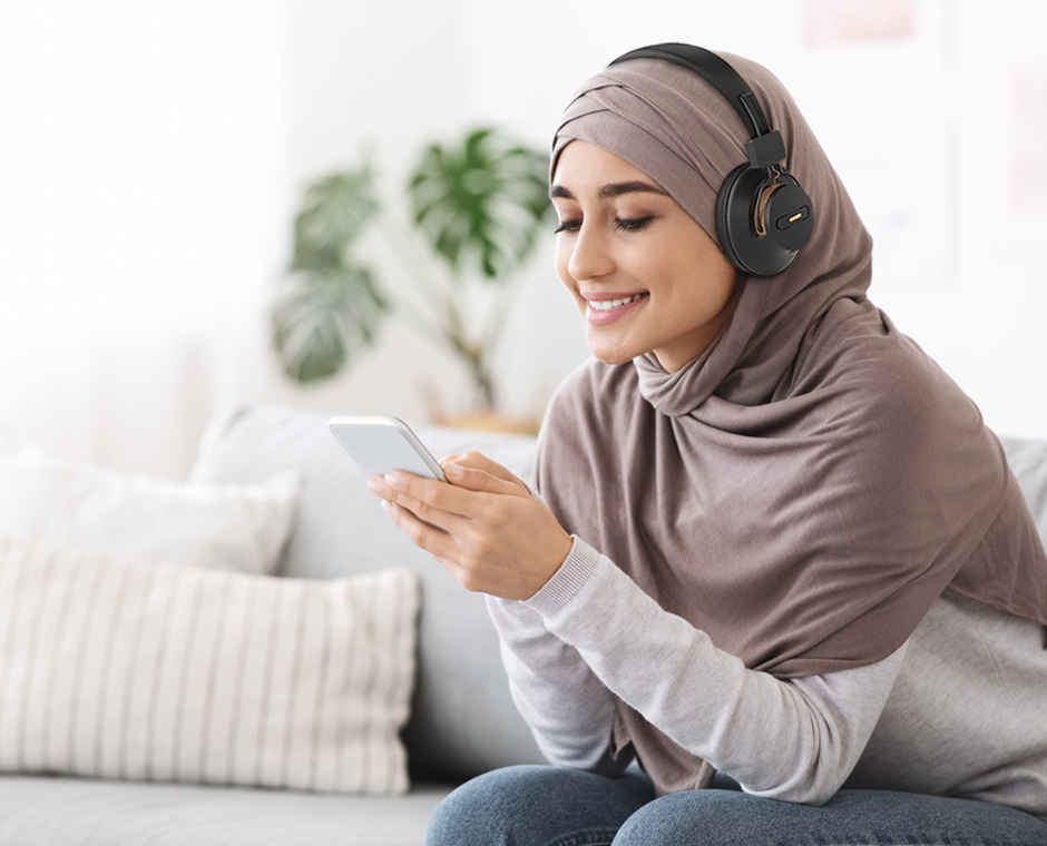 Muslim woman using the Avantree DG59M Bluetooth Headphones independently for listening to music on her iPhone.