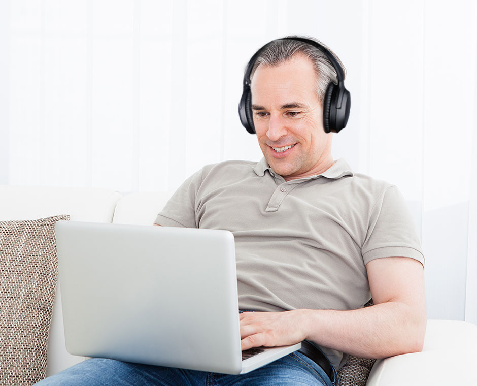 Man using Opera's AS90C Bluetooth 5 headphones independently on his laptop for conference calls and meetings.
